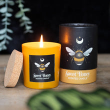 Load image into Gallery viewer, Forest Bee Sweet Honey Candle.  A Sweet Honey fragranced candle decorated with a mystical forest bee design and perfect for creating a magickal ambience. Glass holder with cork lid and beautifully presented in matching cardboard tube packaging.  Vegan paraffin wax. Approximately 25-hour burn time. 